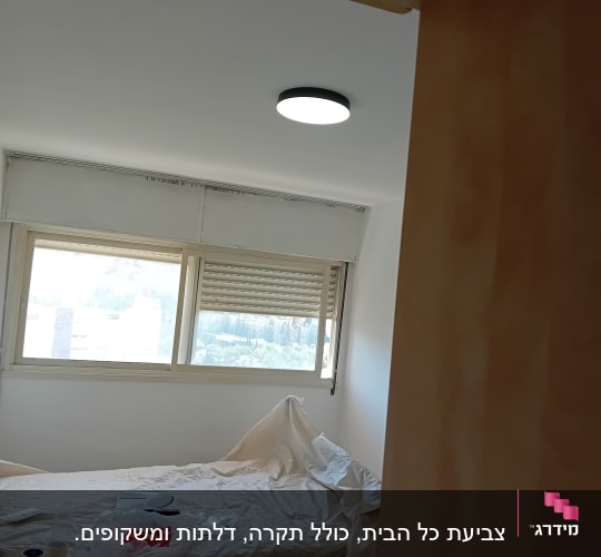 חדר עם קירות צבועים ומיטה מכוסה בניילון